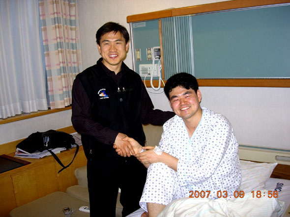▲서동진실무관이지난9일자신을격려하기위해병원을방문한유기돈법원노조서울중앙지부장과악수를하며환하게웃고있는모습(사진=서울중앙지법)