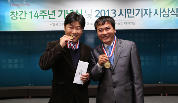 ▲금메달을딴것처럼메달을물어달라는사진기자에포즈를취하는신종철대표(좌),우는이날함께'으뜸상'을수상한김종술시민기자/사진제공=오마이뉴스