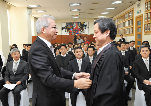 ▲양승태대법원장이연임법관김형진사법연수원교수에게법복을입혀주고있다(사진=대법원)