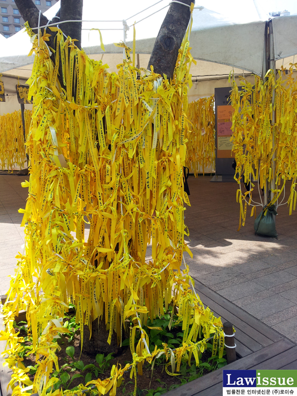 ▲서울광장세월호합동분향소옆에있는나무들에조문객들이매달은노란띠가노란옷을연상케한다.