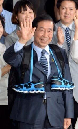 ▲박원순시장이당선직후선물받은운동화를목에걸고환하게손을흔들고있다(박원순페이스북)