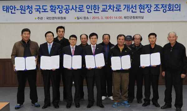 ▲국민권익위원회이성보위원장(가운데)이18일오후태안군청에서국도77호선중몽산포해수욕장등진입교차로구조개선을요구하는고충민원을중재한후관계자들과기념촬영하고있다.(사진=권익위)