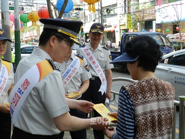 ▲시민들을상대로보이스피싱,대출사기피해예방리플릿을배부하고있다.(사진제공=부산경찰청)