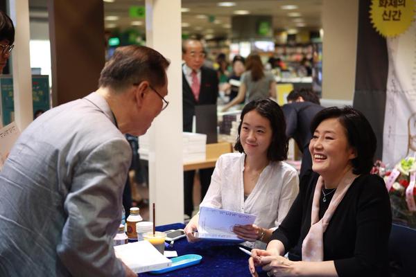 ▲박영선의원이7월25일서울교보문고강남점에서사인한책을독자에게전달하며활짝웃고있다.