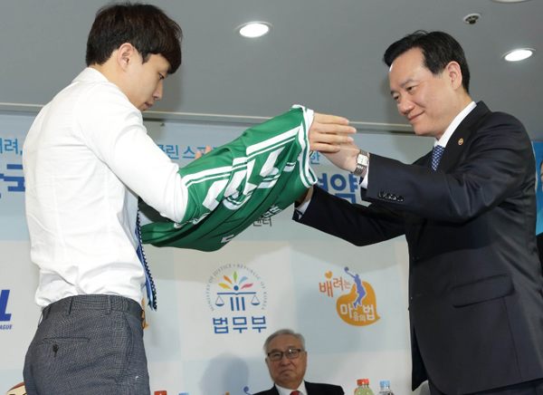 김현웅법무부장관이17일서울강남구KBL센터에서열린배려,법질서실천운동과클린스포츠문화확산을위한법무부·한국프로농구연맹업무협약체결식에서홍보대사로위촉된허웅선수(왼쪽)에게‘배려는마음의법’이라는로고가새겨진유니폼을전달하고있다.(사진=법무부)