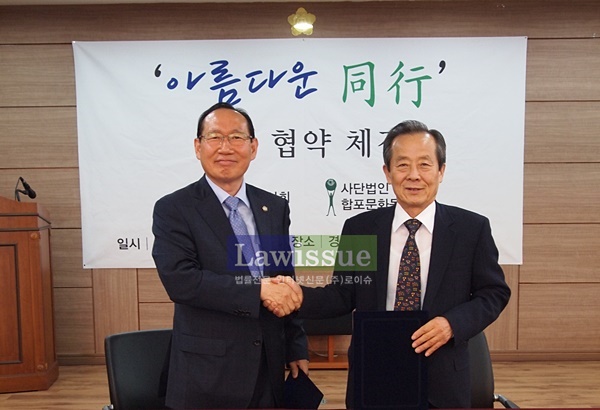 경남지방변호사회 황석보 회장(사진왼쪽)과 합포문화동인회 김조일 이사장이 업무협약을 하고 손을 맞잡고 있다.