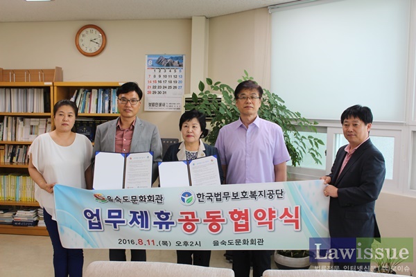 백기영 지부장(왼쪽3번째)과 송필석 관장 등 직원들이 업무제휴협약서를 내보이며 기념촬영.