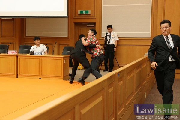 법정소란행위자를 제압하고 있다.