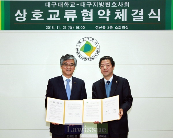 홍덕률 총장(사진왼쪽)과 이재동 회장이 협약서를 내보이며 기념촬영.