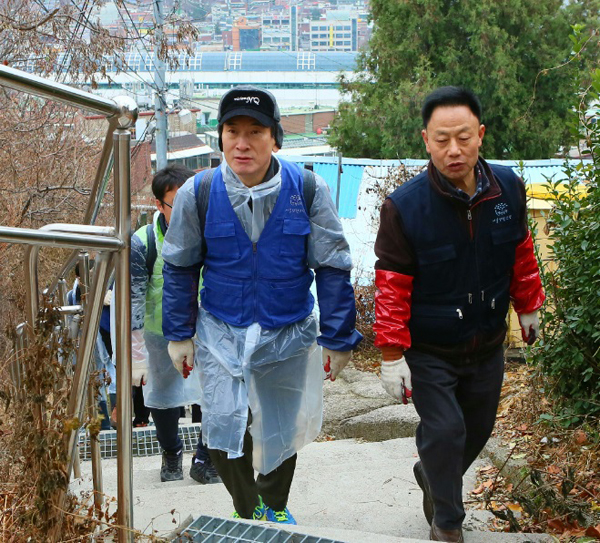 직원들과 함께 연탄을 나르고 있는 김용헌 사무처장(좌)