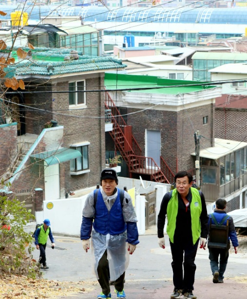 직원들과 함께 연탄을 나르고 있는 김용헌 사무처장(좌)