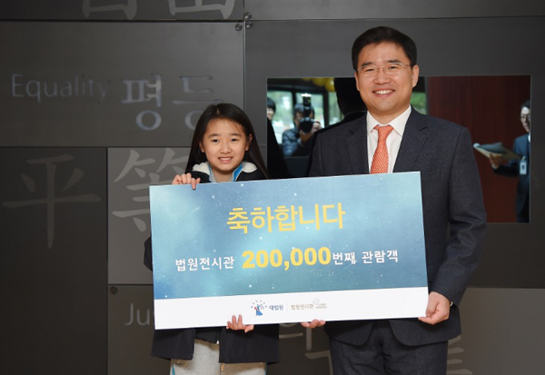 법원전시관 20만번 째 관람객인 김보민 학생과 대법원 조병구 공보관.(사진=대법원)