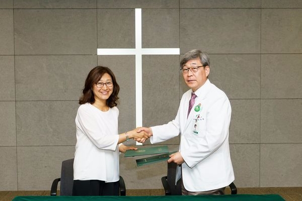 이화여자대학교 의료원과 (사)한국이주민건강협회의 취약 계층 이주민 건강 수호 및 의료 지원 협약식에서 김승철 의료원장(오른쪽)과 김미선 상임이사(왼쪽)가 협약서 사인 후 기념 촬영을 하고 있다