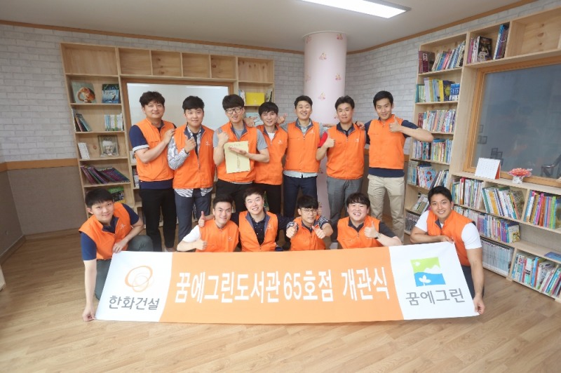 한화건설 신입사원들이 ‘꿈에그린 도서관’ 65호점 개관을 축하하며 기념사진을 촬영하고 있다.(제공=한화건설)