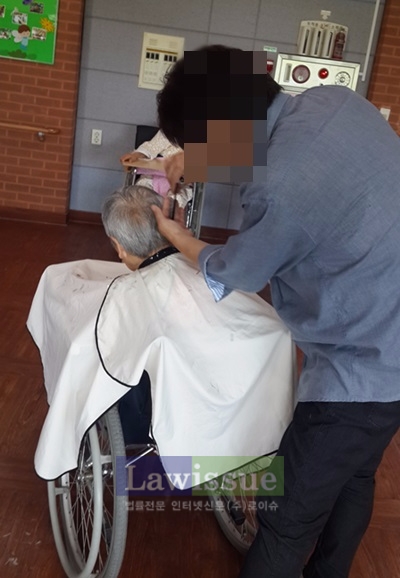 미용특기를 가진 사회봉사대상자가 어르신의 머리를 손질하고 있다.