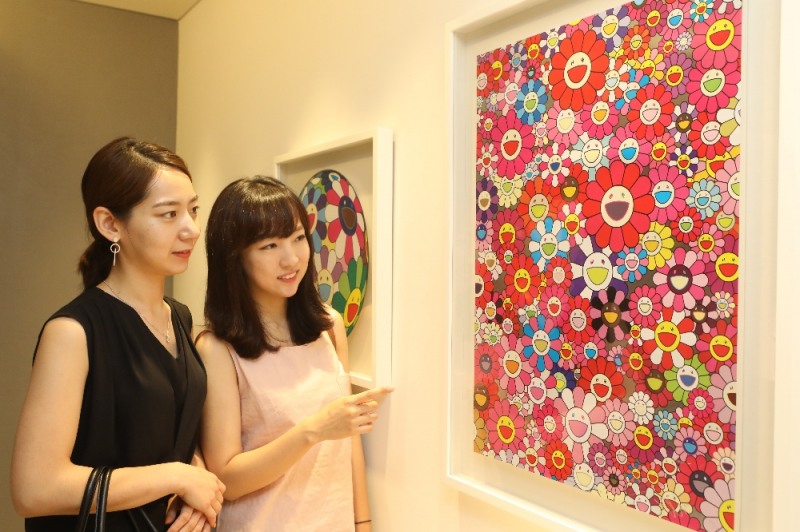고객 2명이 백화점에 전시한 미술 작품을 보는 모습.(사진= 롯데백화점)