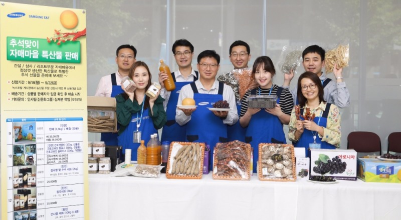 삼성물산 임직원들이 자매마을 특산품을 들고 환하게 웃고 있다.(사진=삼성물산)