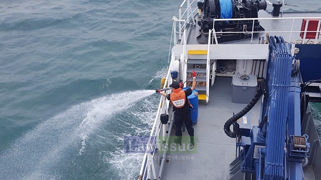 유출된 기름띠 방제작업을 하고 있다.