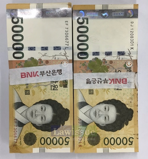 70대 노인이 부주의로 길바닥에 떨어뜨린 5만원권 100매 2묶음.(사진=부산금정경찰서)