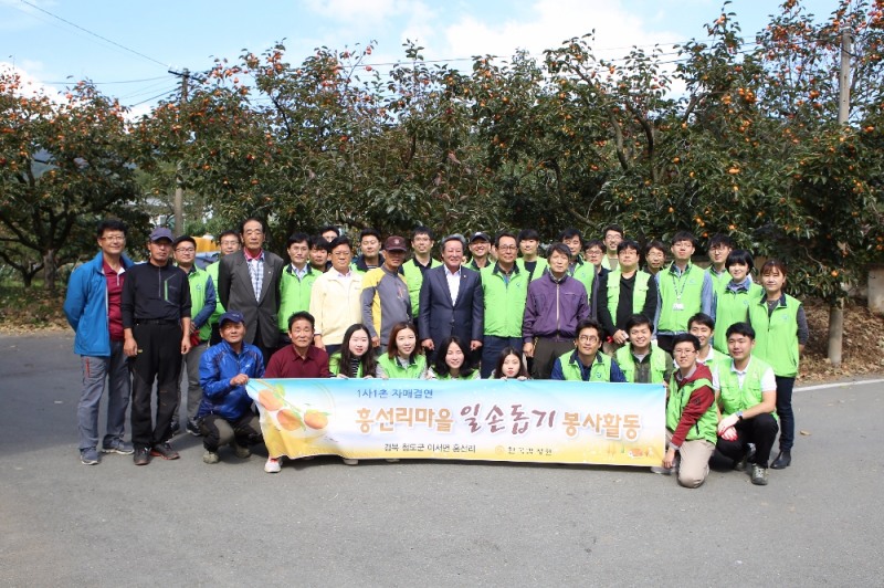 한국감정원 임직원들이 흥선리 마을에서 감 따기 봉사활동 실시 후 단체사진 촬영을 하고 있다.(사진=한국감정원)