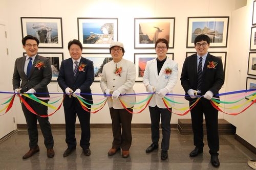 유디갤러리 ‘늘 푸른 우리 독도 사진전’ 개막식 테이프 커팅하는 모습(사진= 유디치과)