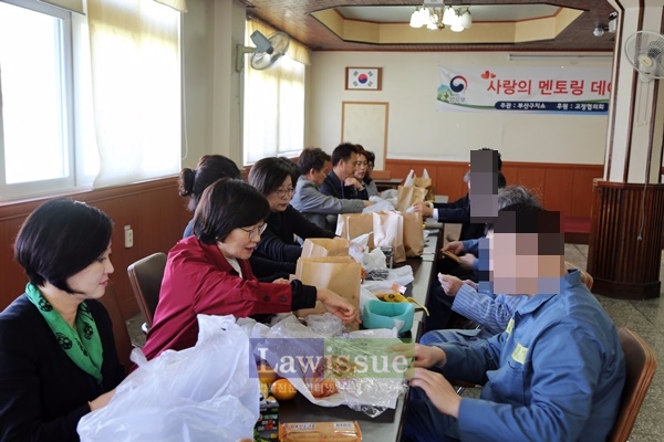 교정위원들과 수형자들이 음식을 나눠먹으며 대화를 하고 있다.
