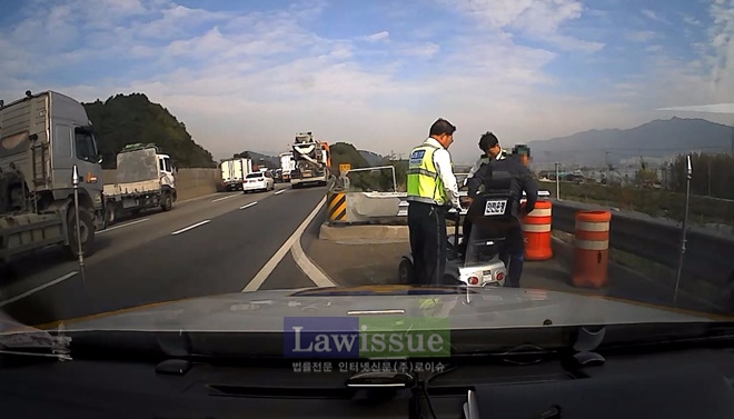 고속도로순찰대가 전동휠체어를 타고 고속도로를 운행하던 할아버지를 발견하고 후송조치하고 있다.