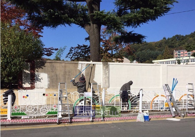 사회봉사대상자들이 벽화그리기 사전작업으로 페인트칠을 하고 있다.
