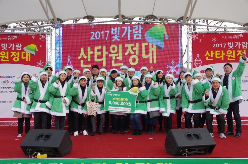 한전KPS 한마음봉사단이 ‘2017 산타원정대’에 참가해 지역 아동들에게 전달한 후 기념촬영을 하고 있다.(사진=한전KPS)
