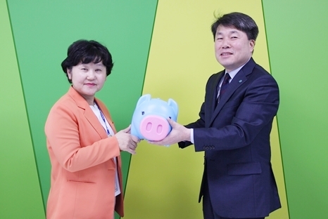 가톨릭대 인천성모병원 간호부 조정애 팀장(왼쪽)이 미화부 인용선 소장(오르쪽)에게 희망돼지기금을 전달하고 있다.