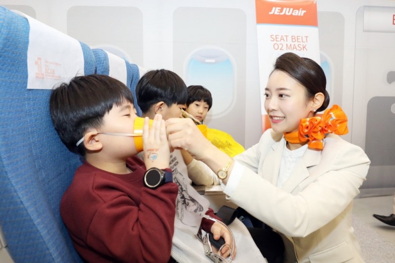 제주항공 객실승무원들이 22일 오전 서울 동대문디자인플라자에서 열리고 있는 제7회 어린이 안전짱 체험박람회에서 ‘항공안전체험교실’에 참여한 어린이들에게 비상상황 발생시 산소마스크 착용방법을 가르쳐 주고 있다. (사진=제주항공)