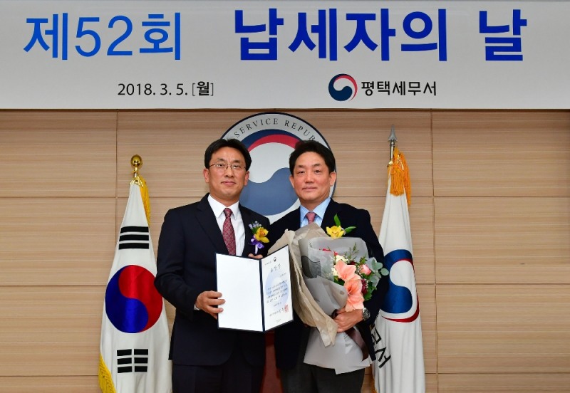 농심켈로그 한종갑 대표이사,사장(우)이 ‘제52회 납세자의 날’ 기념식에서 김동욱 평택세무서장(좌)에게 기획재정부장관상을 수여 받고 있다.(진=농심켈로그)