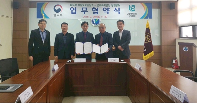 양 기관이 업무협약서를 내보이며 기념촬영을 하고 있다.(사진제공=창원준법지원센터)