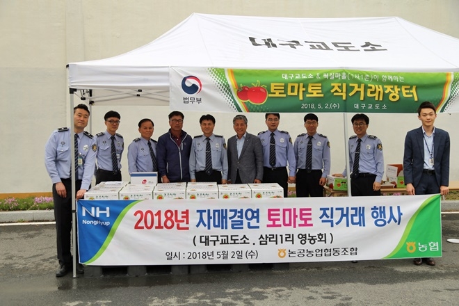 토마토직거래 행사를 갖고 기념촬영을 하고 있다.(사진제공=대구교도소)