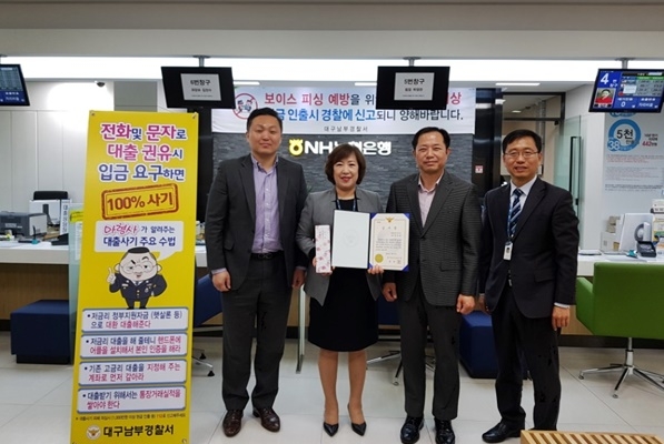 보이스피싱 예방한 농협은행 하영란 팀장에게 감사장을 전달하고 기념촬영을 하고 있다.(사진제공=대구남부경찰서)