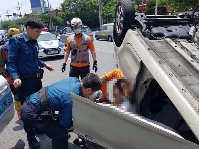 경찰관과 시민이 운전자를 구조하고 있다.(사진제공=부산지방경찰청)