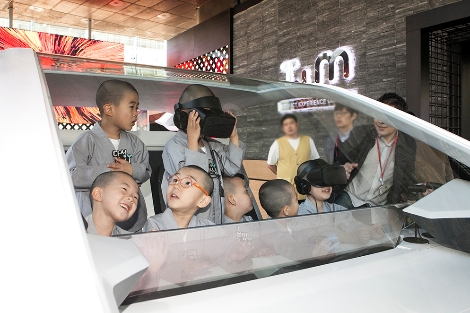 21일 서울 중구 소재 SK텔레콤 ICT체험관 '티움(T.um)'을 방문한 동자승들이 자율주행차에 앉아 미래 주행을 체험하고 있는 모습. (사진=SK텔레콤)