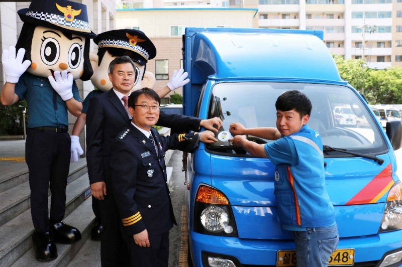 김홍근 동대문경찰서장과 진상훈 CJ대한통운 상무가 이재황씨 택배차량에 '포돌이 안심택배' 인증 스티커를 부착하고 있다. (사진=CJ대한통운)