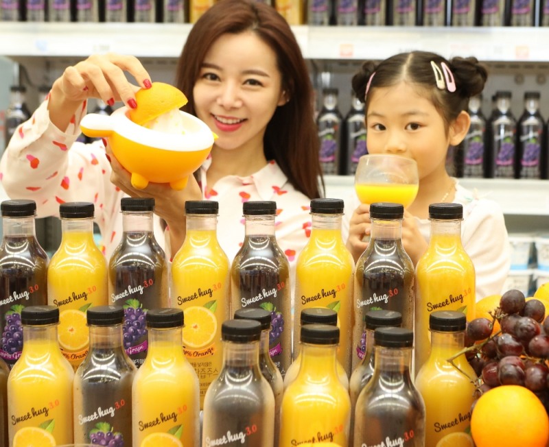 롯데마트 서울역점에서 모델들이 '스윗허그 100% 착즙주스'를 소개하고 있다. (사진=롯데마트)