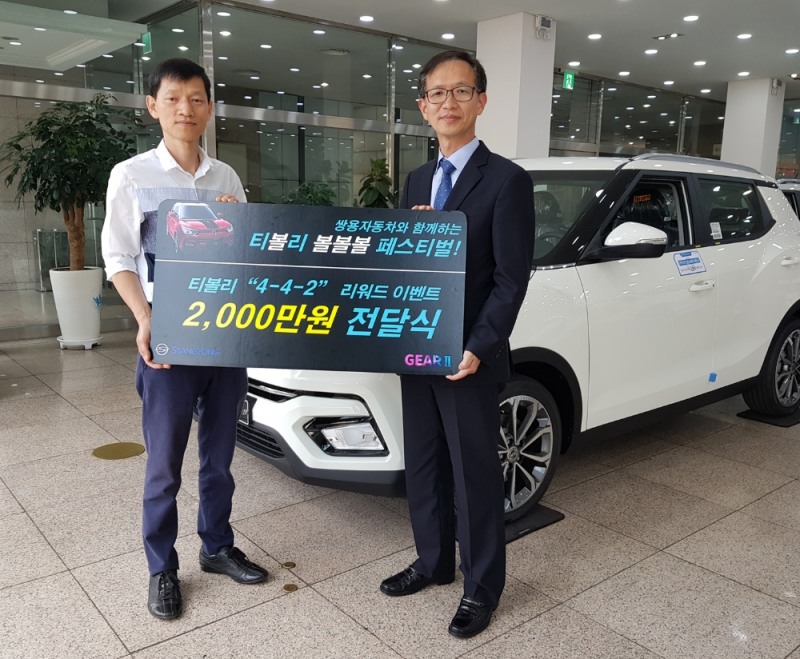 쌍용자동차 박세홍 경인지역본부장(오른쪽)이 2천만원 페이백 행운의 주인공이 된 권영욱씨(52세, 경기 부천)에게 경품을 전달하고 있다.(사진=쌍용자동차)