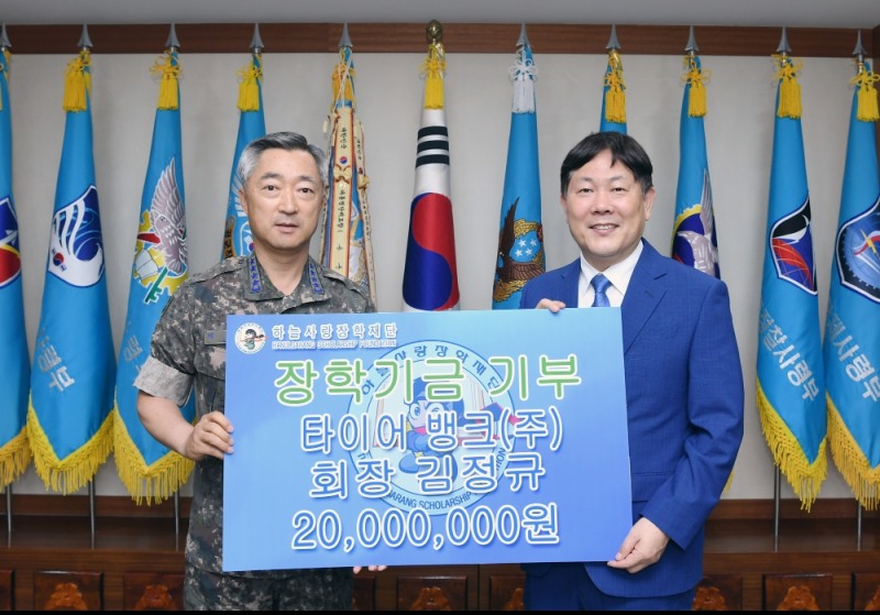 타이어뱅크 김정규 회장이 21일 충남 계룡시 공군본부에서 참모총장 이왕근 대장에게 장학금을 전달하고 기념 촬영을 하고 있다.(사진=타이어뱅크)