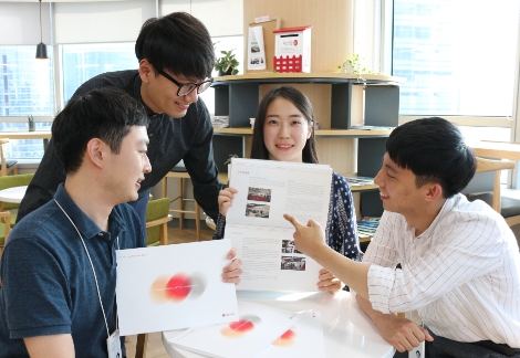 LG이노텍 신입사원들이 지속가능경영 보고서를 함께 살펴보고 있다. (사진=LG이노텍)