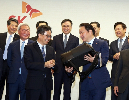 지난 3월, SK그룹을 방문한 김동연(중앙 左) 경제부총리 겸 기획재정부 장관이 최태원(중앙 右) 회장으로부터 구매한 컨티뉴 가방을 전달 받고 있다. 
