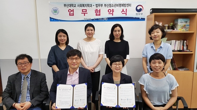 업무협약서를 내보이며 기념촬영을 하고 있다.(사진제공=부산청소년비행예방센터)