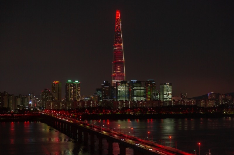 롯데는 21일 롯데월드타워에서 스포츠와 문화예술을 통해 발달장애인이 포용받는 사회를 만들어가자는 취지의 스페셜올림픽 50주년 기념 점등식 ‘Light Up For Inclusion’을 개최했다. 사진은 붉은 빛이 점등된 롯데월드타워의 모습. (사진=롯데)