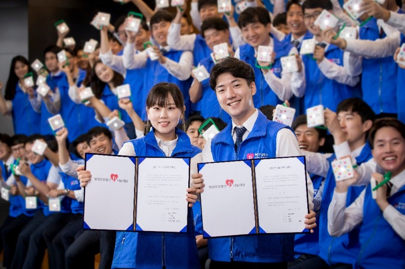 현대오일뱅크 신입사원들이 에너지 빈곤 국가에 보낼 태양광 랜턴을 조립하고 급여 1% 나눔 약정서에 사인한 후 포즈를 취하고 있다.(사진=현대오일뱅크)