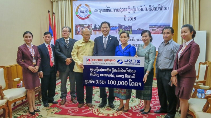 부영라오은행 김석진 행장(왼쪽에서 다섯번째)이 라오스 노동복지부 바이캄 캇티야 차관(오른쪽에서 네 번째)을 만나 10만 달러의 수재 구호성금을 전달했다. 왼쪽에서 네 번째는 부영그룹 께올라 고문(前 주한 라오스 대사).(사진=부영그룹)