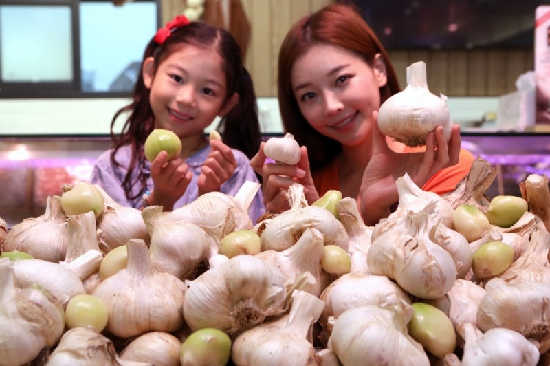 8일 모델들이 롯데프리미엄푸드마켓 공덕점에서 주먹만한 마늘을 소개하는 모습 (사진=롯데슈퍼)