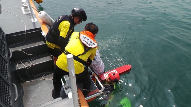 투신자를 구조하고 있다.(사진제공=부산해양경찰서)