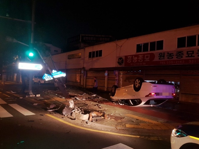 음주에 졸음운전하다 가로등 등을 들이받고 전복한 차량.(사진제공=부산지방경찰청)